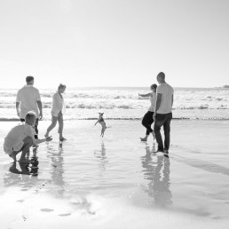 A family plays with their dog on a Sunshine Coast beach